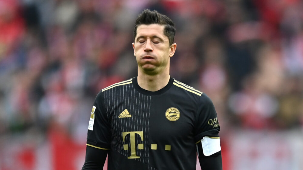 Robert Lewandowski pustet durch. Er trägt das schwarz-goldene Trikot des FC Bayern aus einer vergangenen Spielzeit.