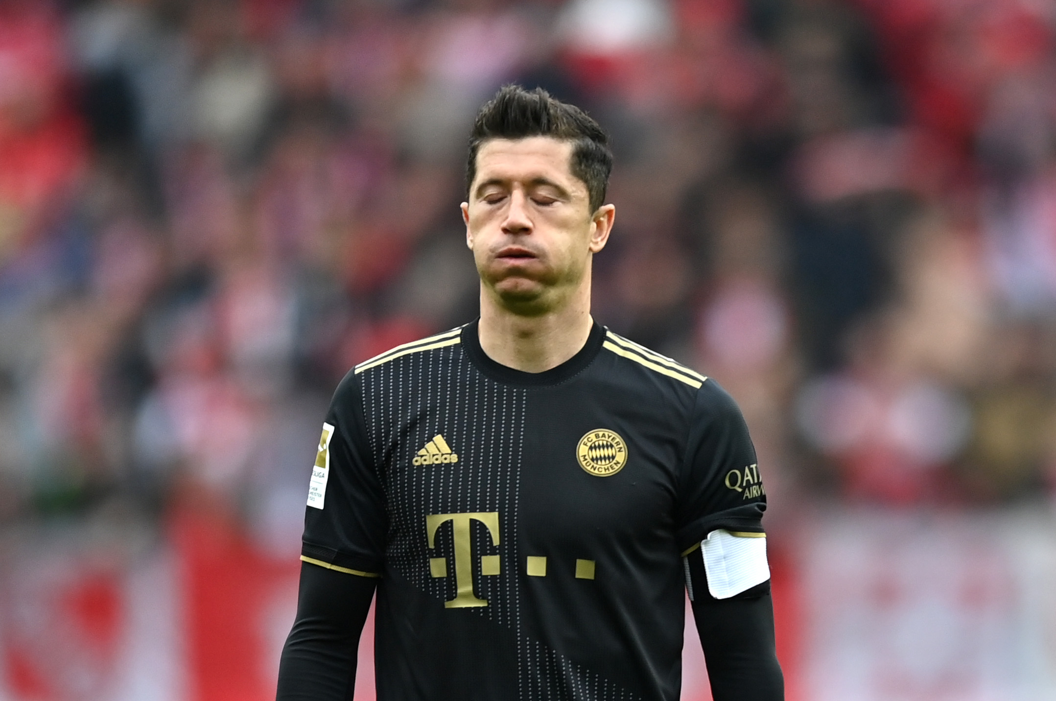 Robert Lewandowski pustet durch. Er trägt das schwarz-goldene Trikot des FC Bayern aus einer vergangenen Spielzeit.