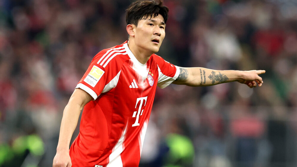 Min-jae Kim im Trikot des FC Bayern. Er zeigt mit dem linken Arm zur Seite.