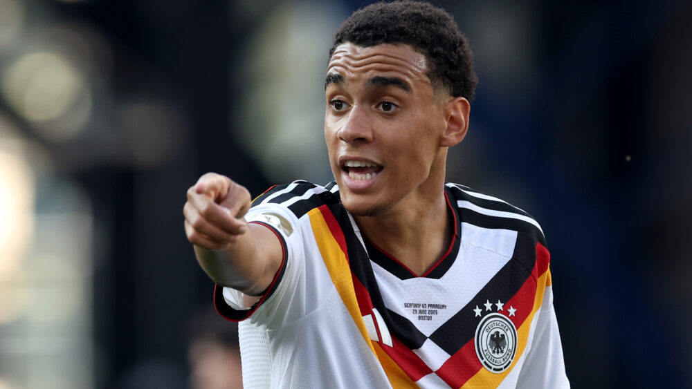 Jamal Musiala (FC Bayern) hier im DFB-Trikot. Er zeigt nach vorn und sieht angespannt aus.