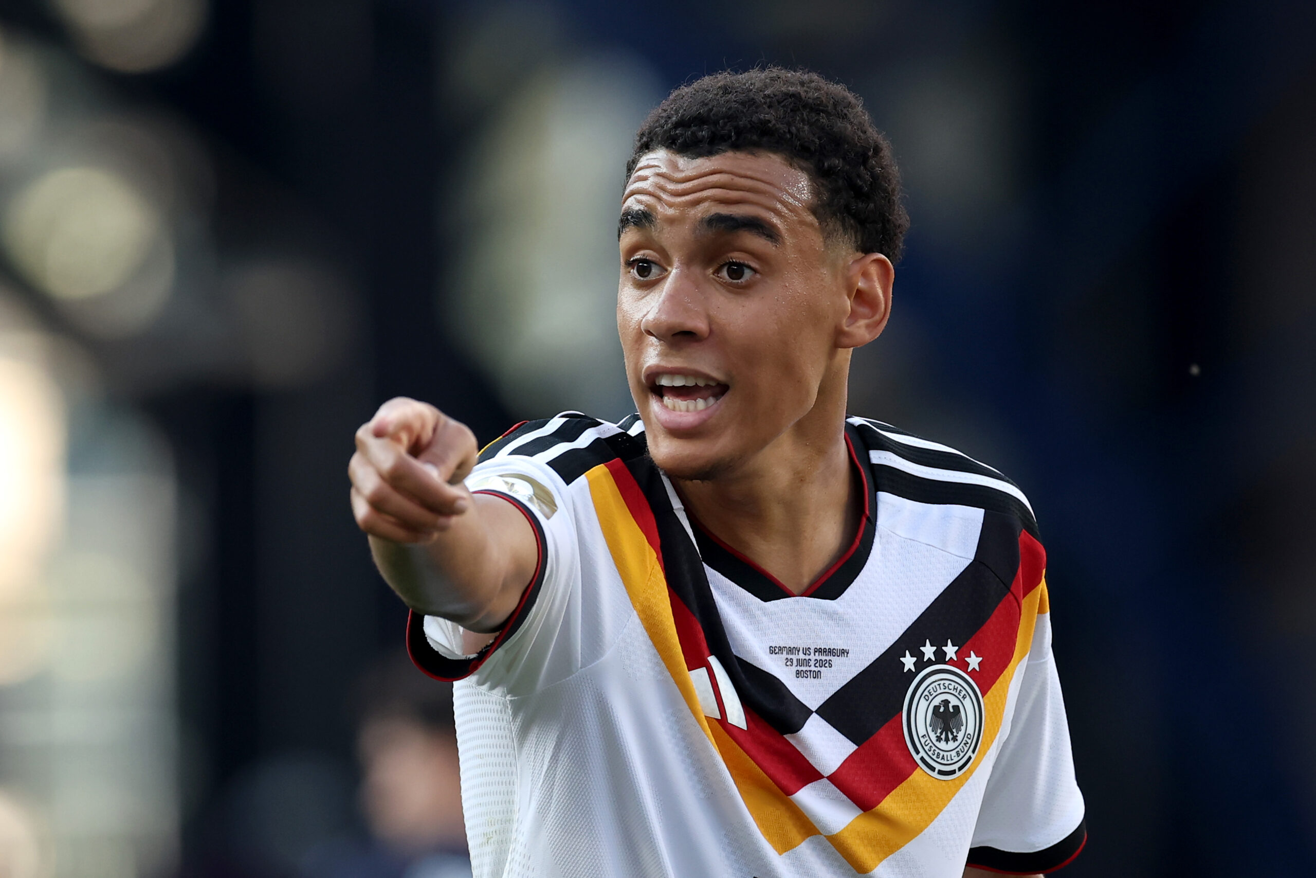 Jamal Musiala (FC Bayern) hier im DFB-Trikot. Er zeigt nach vorn und sieht angespannt aus.