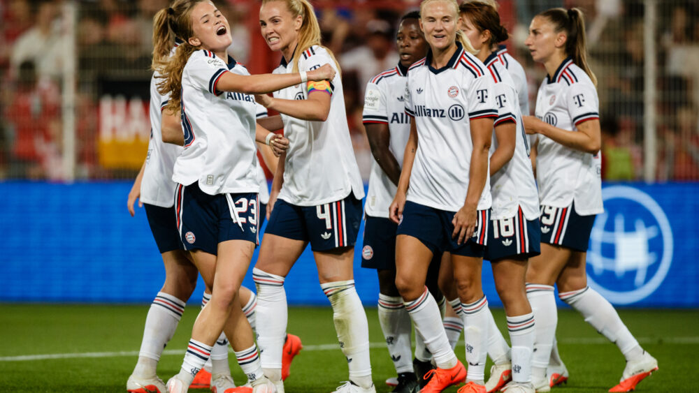 FC Bayern Frauen jubeln gemeinsam im weißen Auswärtstrikot.
