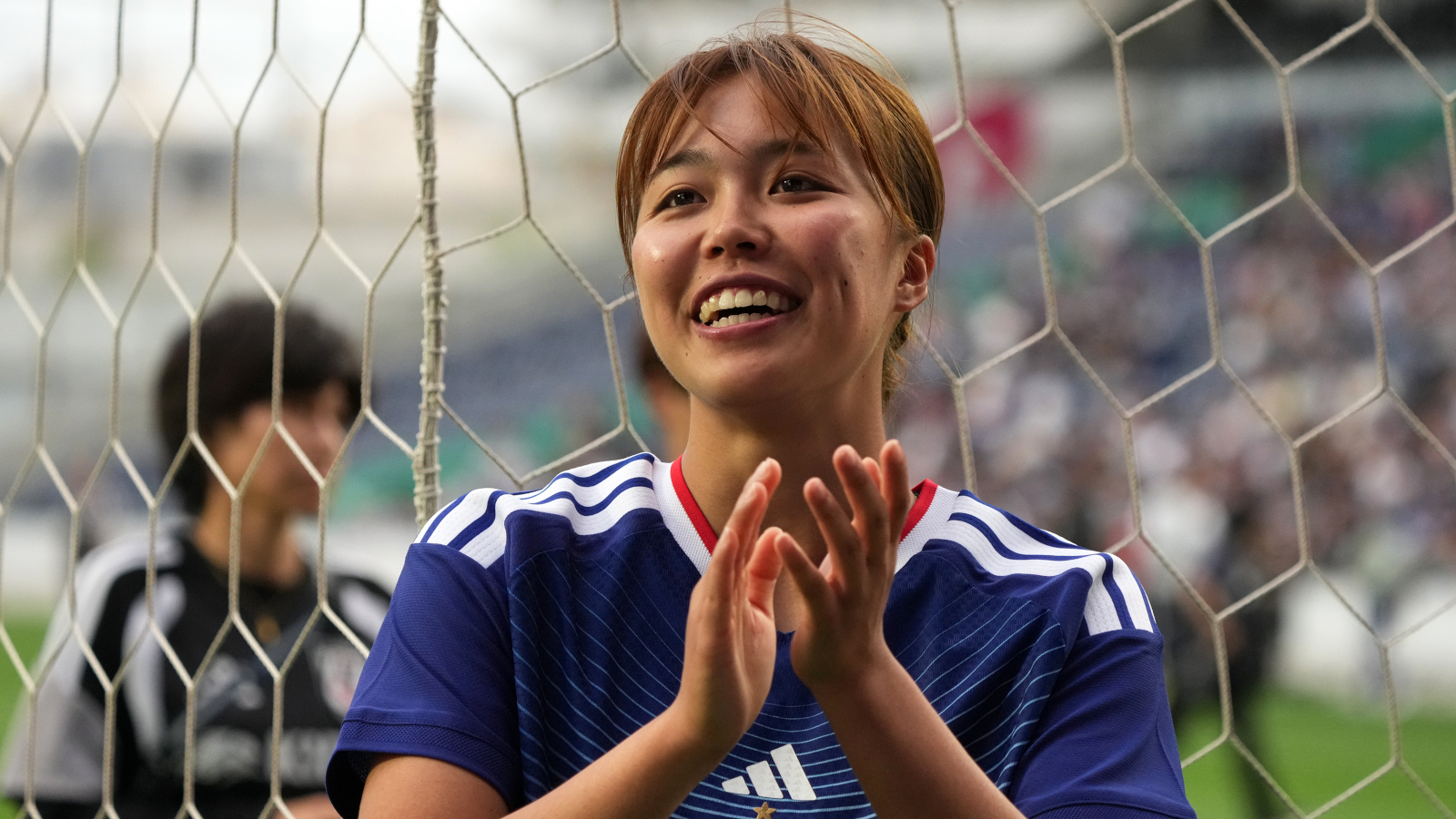 Momoko Tanikawa (FC Bayern) hier im blauen Trikot von Japan. Sie lacht und klatscht in die Hände.